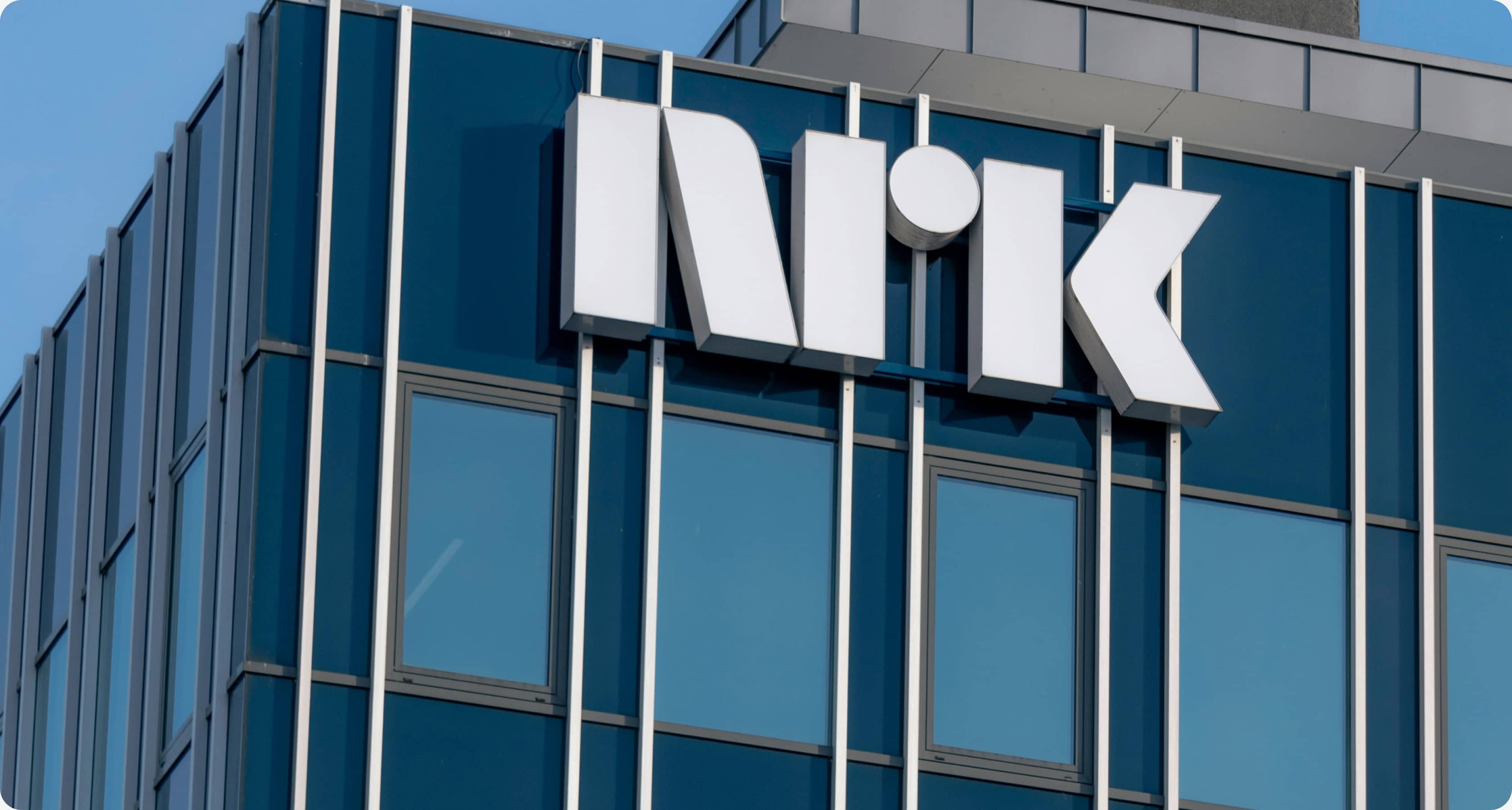 Fasaden på NRK-bygget med en hvit NRK-logo montert på blå glassvegger.