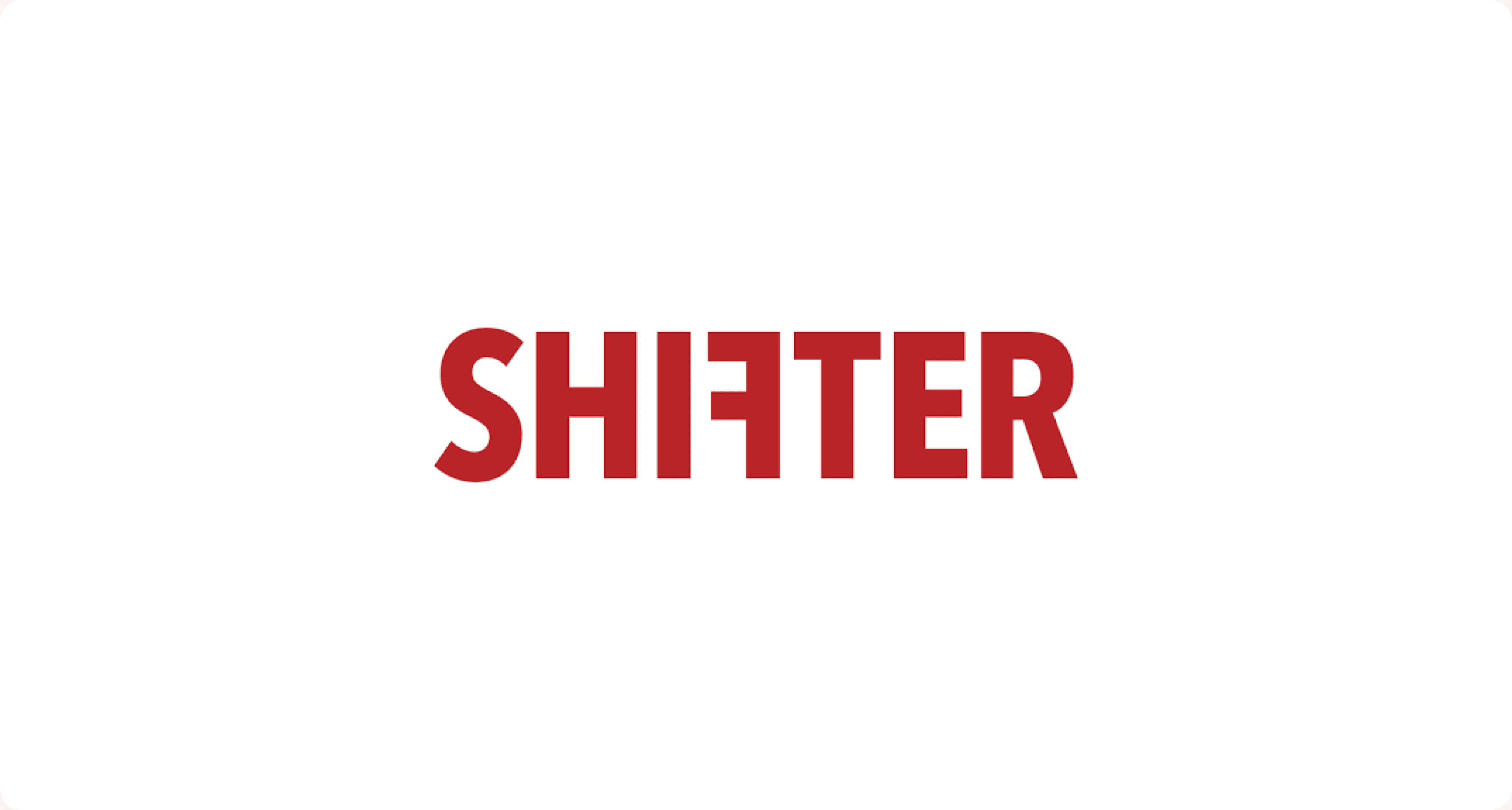 To personer i Shifter-redaksjonen ser på en bærbar PC ved et møtebord, med rød SHIFTER-logo på veggen i bakgrunnen.
